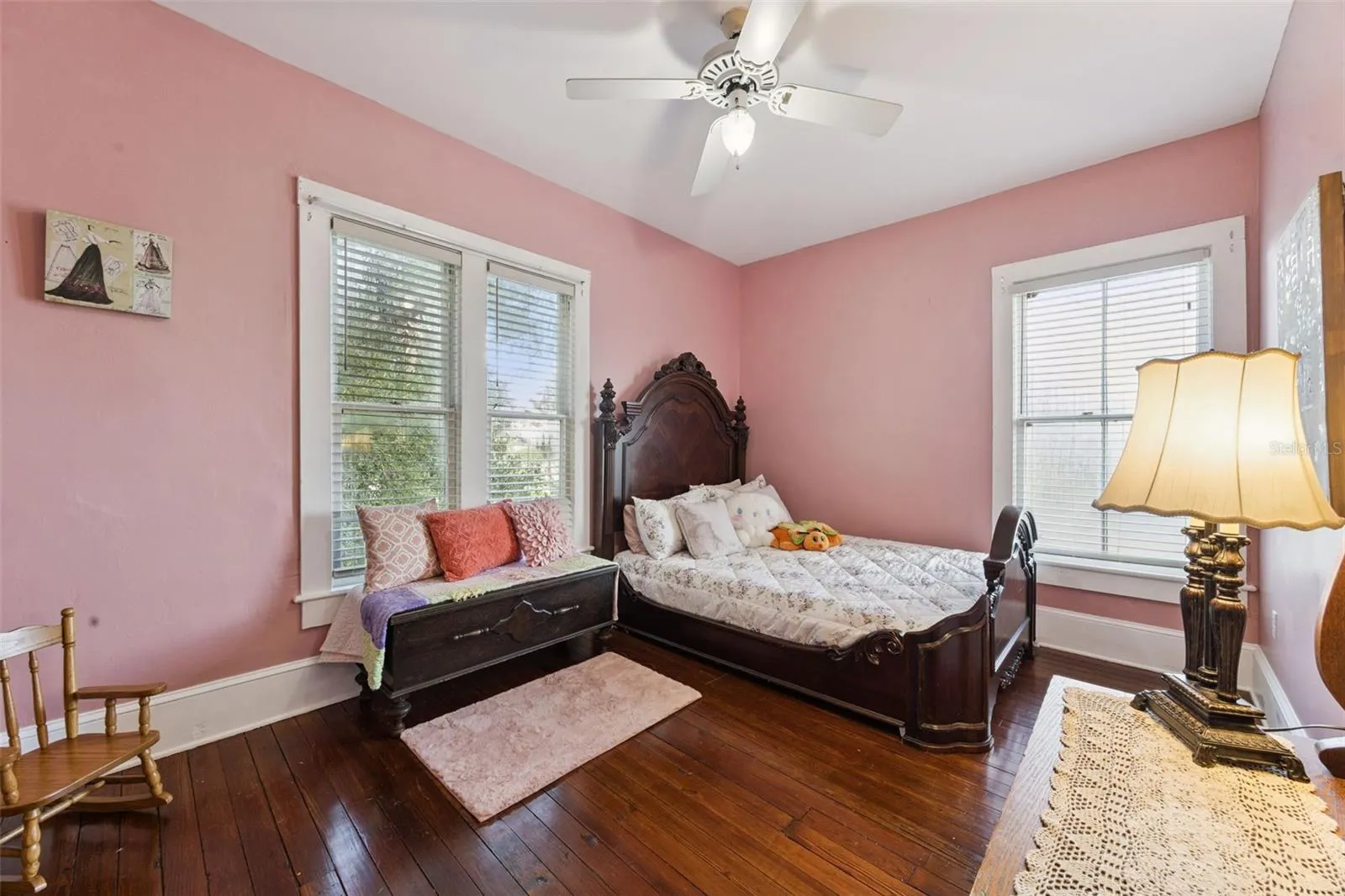 Another spacious upstairs bedroom features beautiful wood floors, tall windows and abundant natural light.