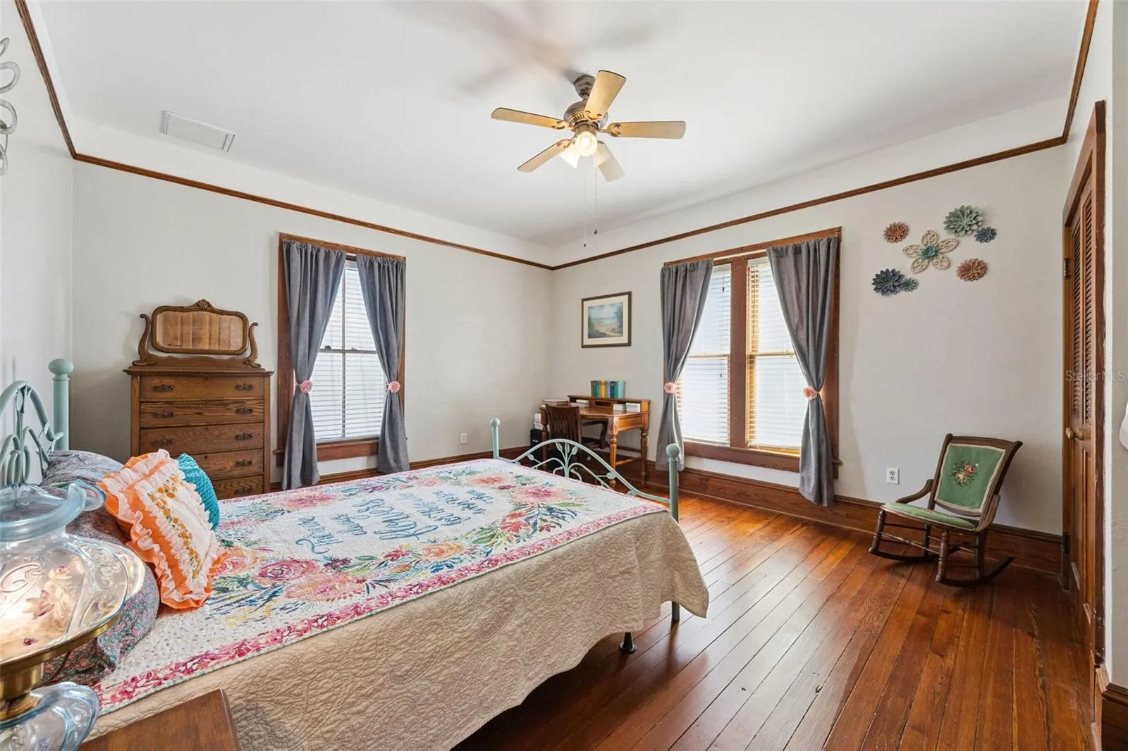 Another spacious upstairs bedroom features beautiful wood floors, tall windows and abundant natural light.