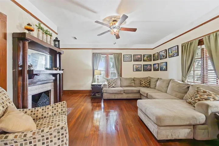 The spacious living room opens through original French doors to the central hall, preserving the home's classic floor plan and architectural detail.
