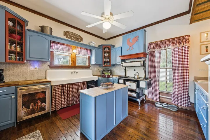 Full of personality, the kitchen pairs blue cabinetry and warm wood floors with a farmhouse sink and striking vintage-style range.