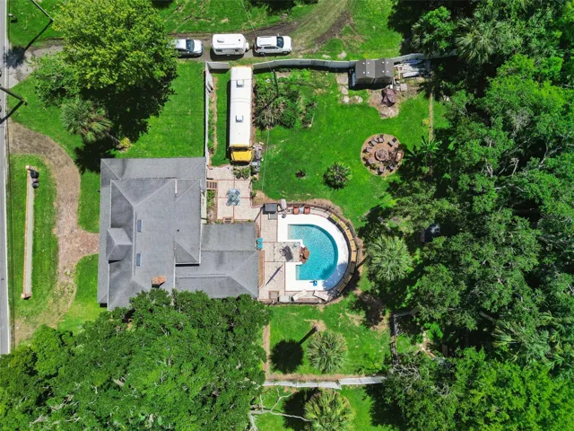 From above, the property's scale becomes clear: a substantial historic home, private pool, outdoor living areas and expansive grounds.