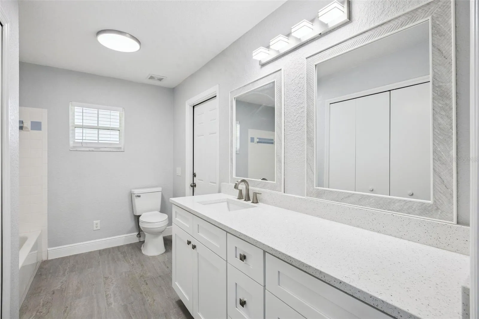 guest bath with large linen closet, tall vanity with Quartz top, tub and shower combination and direct access to the covered patio