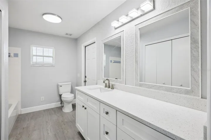 guest bath with large linen closet, tall vanity with Quartz top, tub and shower combination and direct access to the covered patio