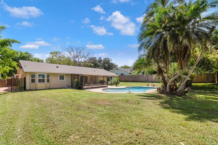 The expansive yard and mature trees create a backyard oasis.