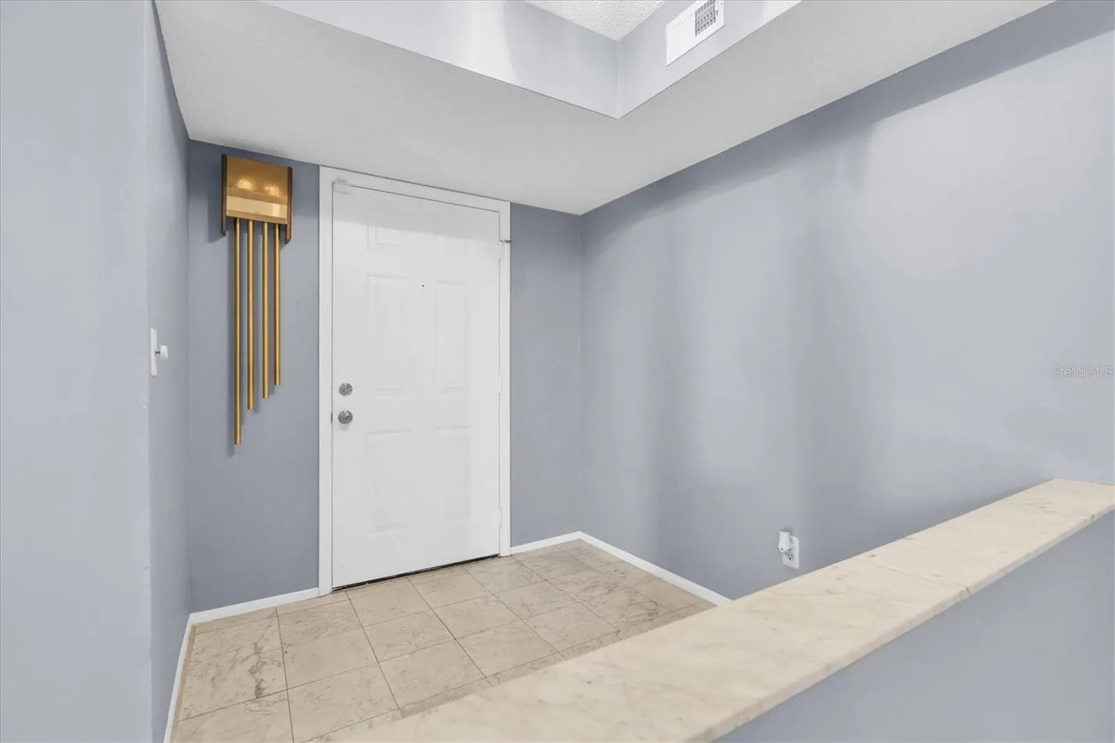 Interior entryway inside the unit with half wall looking into the dining room and open living area.