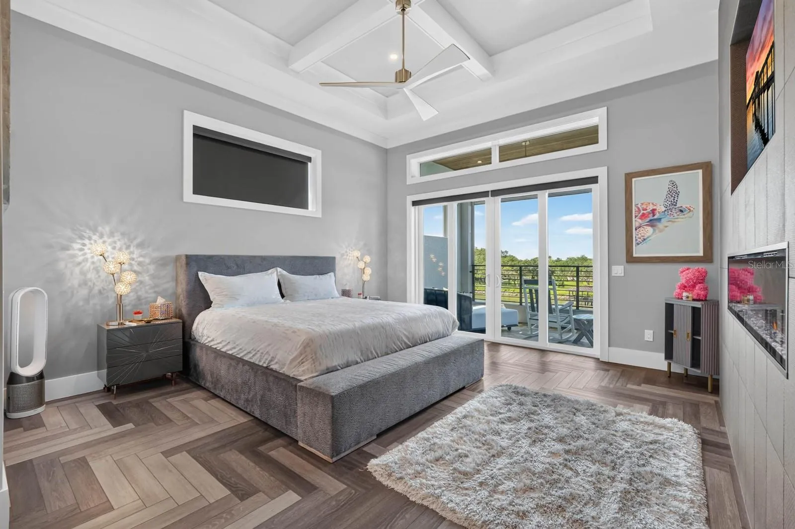 Wake up to the water.A spacious primary suite with architectural ceilings, fireplace and direct access to its own covered balcony.