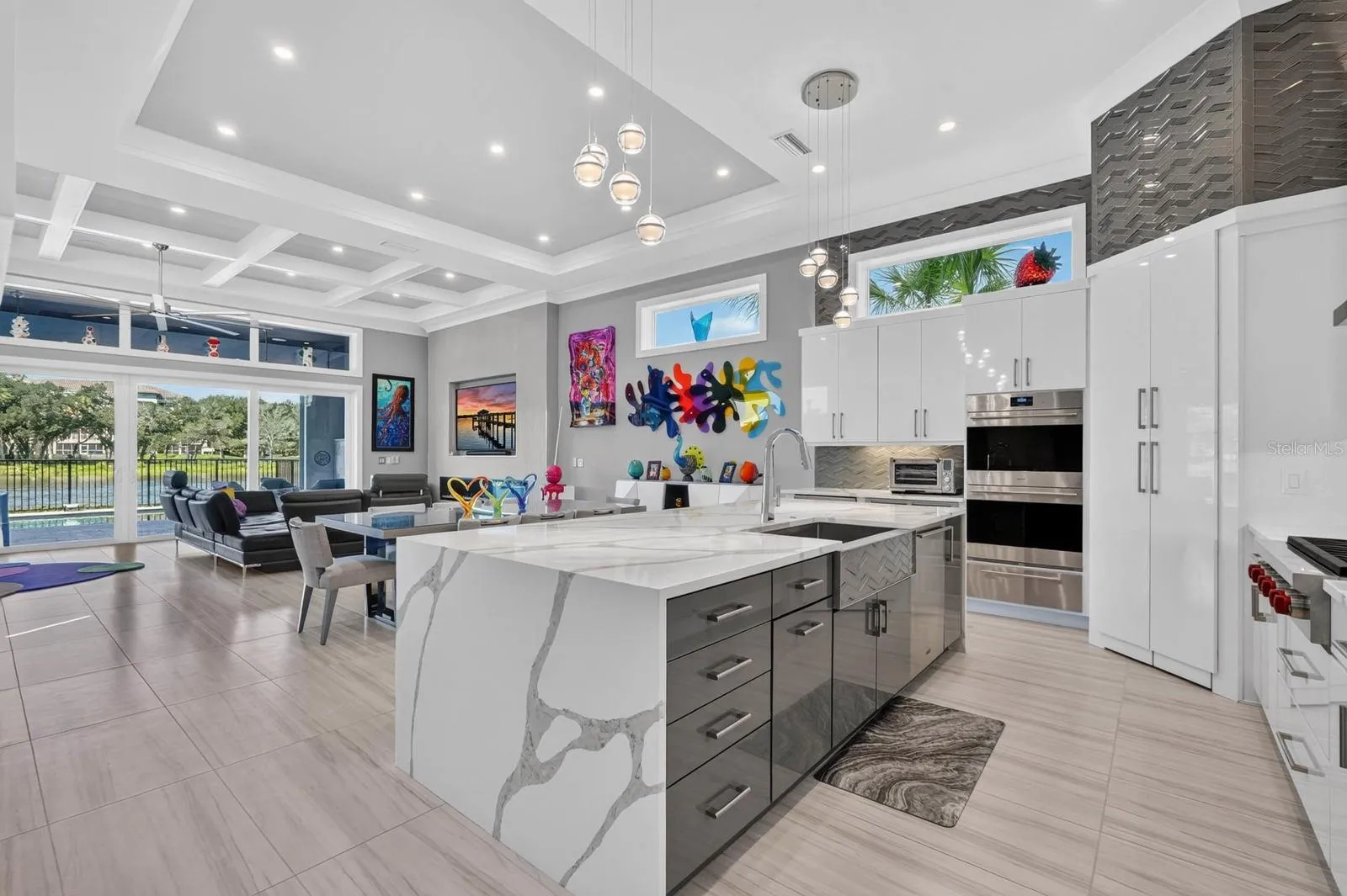 A kitchen built to be used and enjoyed. Statement quartz surfaces, custom cabinetry, premium appliances and designer lighting anchor the open-concept main living level, with the Intracoastal always in view.