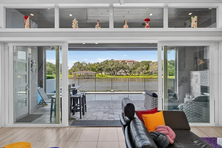 Open the glass doors and indoor-outdoor living becomes one—pool, covered lanai and wide water views extending naturally from the main living space.