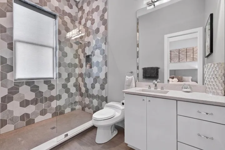 The private ensuite continues the clean, contemporary design with an oversized walk-in shower and beautiful tile detail.