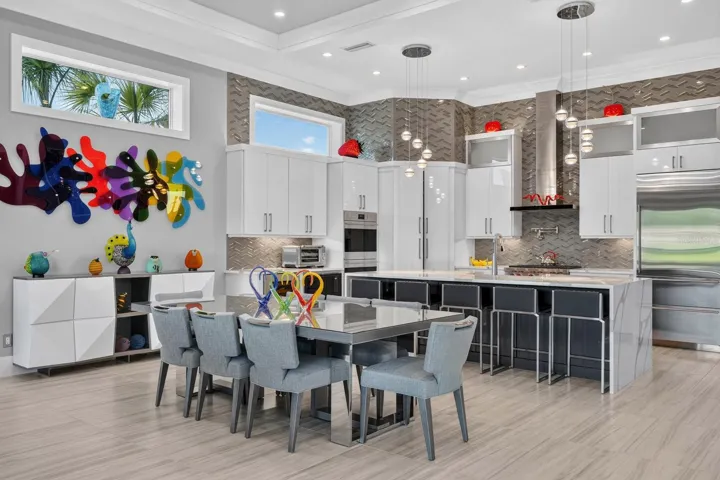 Designed to gather. An expansive open kitchen and dining area with soaring ceilings, designer lighting, custom cabinetry and professional-grade appliances creates a natural centerpiece for the main living level.