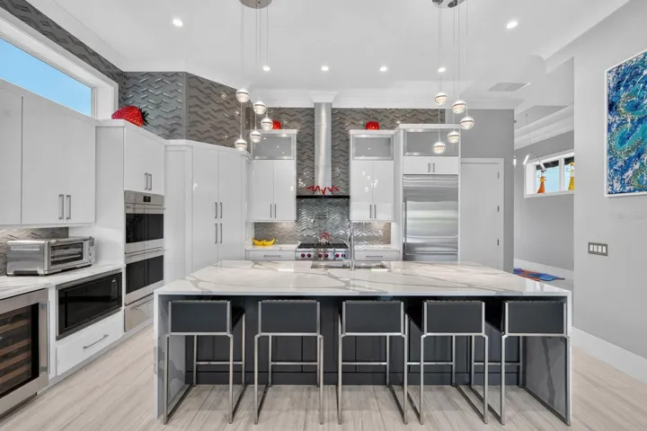 A kitchen designed without compromise—Sub-Zero refrigeration, Wolf cooking, built-in wine storage, abundant cabinetry and dramatic ceiling-height finishes create a space that is both polished and highly functional.