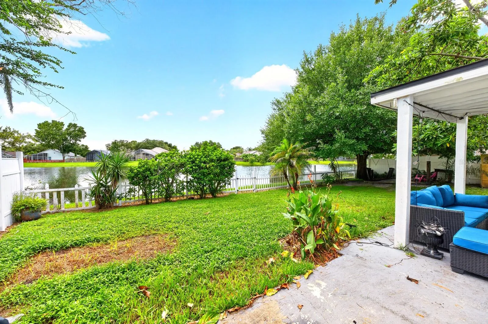 Step outside where the VINYL-FENCED YARD takes full advantage of the PEACEFUL LAKE SETTING as you relax on the COVERED PATIO and enjoy the water view.