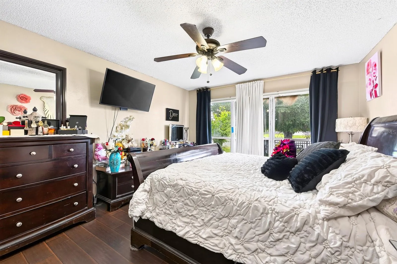 The Primary Bedroom IS CONVENIENTLY LOCATED ON THE MAIN FLOOR and features easy-care LAMINATE FLOORING, sliding glass doors to the back patio, a WALK-IN CLOSET and an UPDATED EN-SUITE BATH (2022).