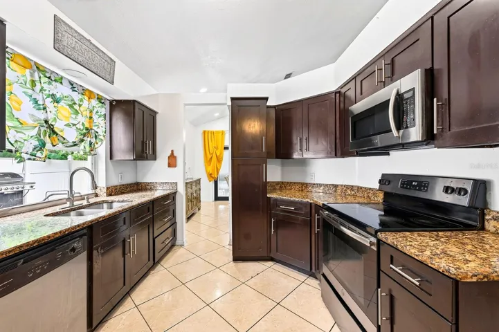 The spacious Kitchen is designed for both everyday meals and entertaining, offering STONE COUNTERTOPS, abundant cabinetry, and STAINLESS STEEL APPLIANCES.