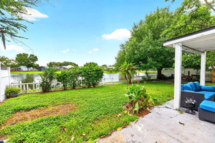 Step outside where the VINYL-FENCED YARD takes full advantage of the PEACEFUL LAKE SETTING as you relax on the COVERED PATIO and enjoy the water view.
