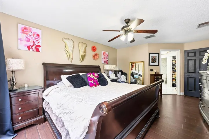 The Primary Bedroom IS CONVENIENTLY LOCATED ON THE MAIN FLOOR and features easy-care LAMINATE FLOORING, sliding glass doors to the back patio, a WALK-IN CLOSET and an UPDATED EN-SUITE BATH (2022).