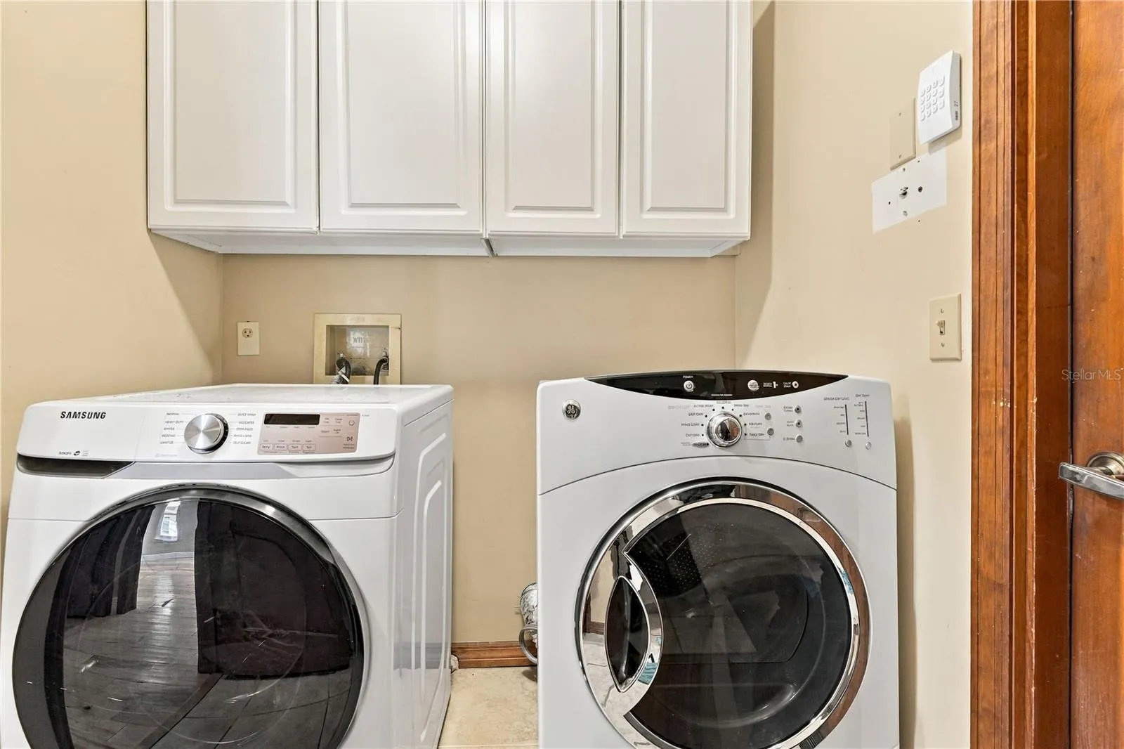 Indoor laundry room with storage cabinetry.
