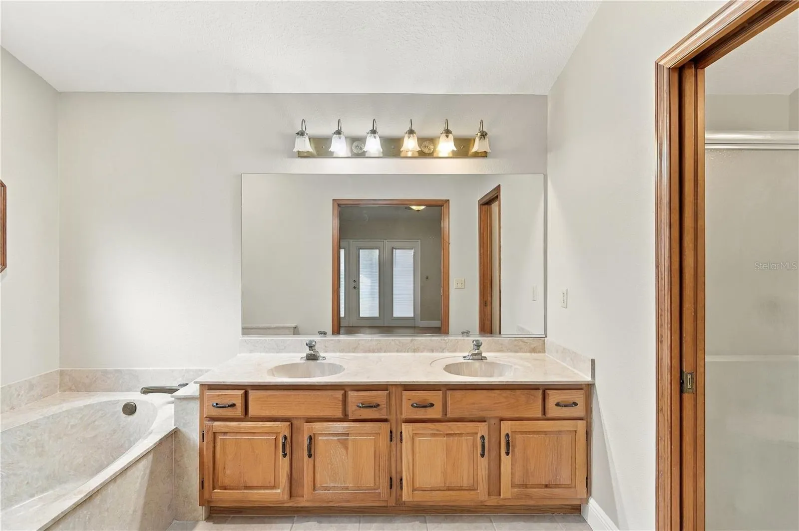 Primary bathroom with dual-sink vanity and soaking tub.