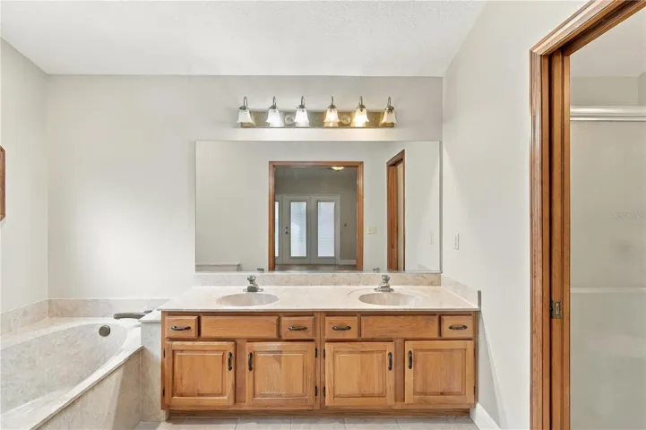 Primary bathroom with dual-sink vanity and soaking tub.