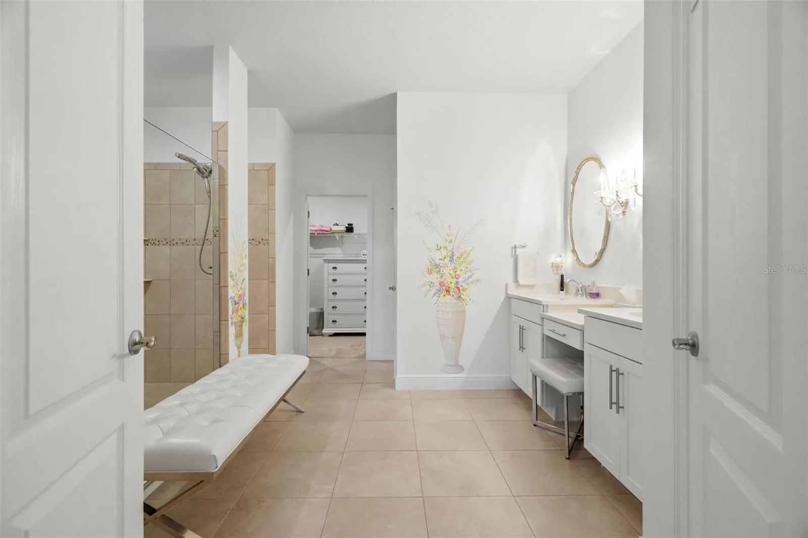 Spacious primary bath with dual vanities, extensive tilework and an oversized walk-in shower.
