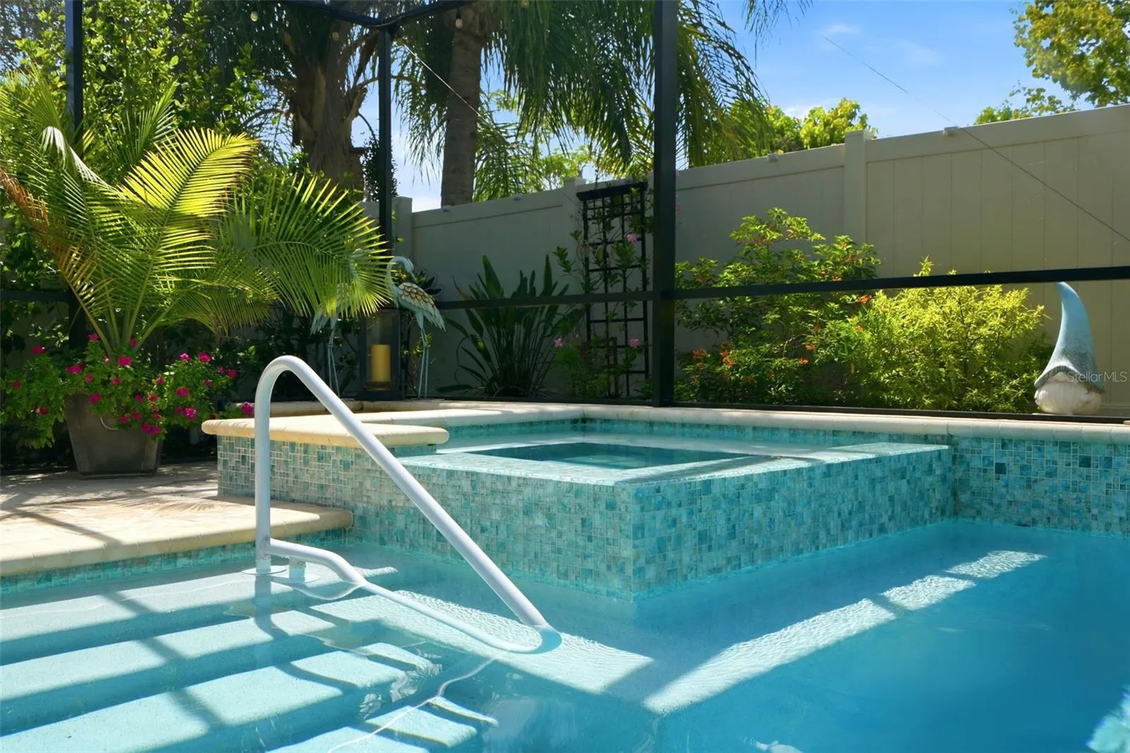 Raised spa complements the screened saltwater pool and outdoor living area.