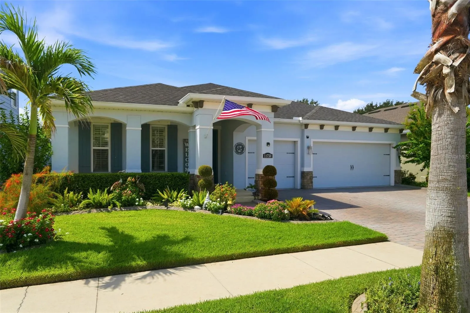 Custom modern farmhouse shutters, added gutters, decorative landscape curbing and manicured landscaping enhance the exterior.