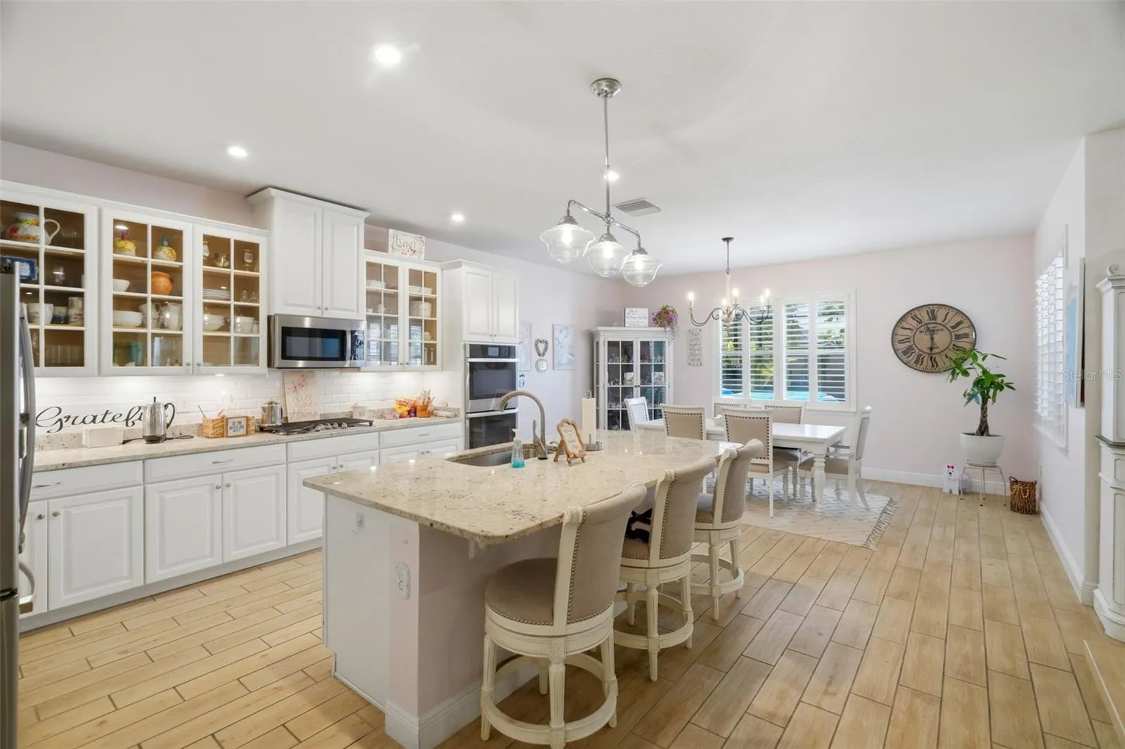 Glass-front cabinetry adds a custom touch to the kitchen design.