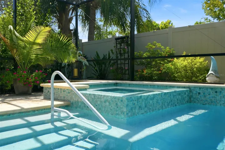 Raised spa complements the screened saltwater pool and outdoor living area.