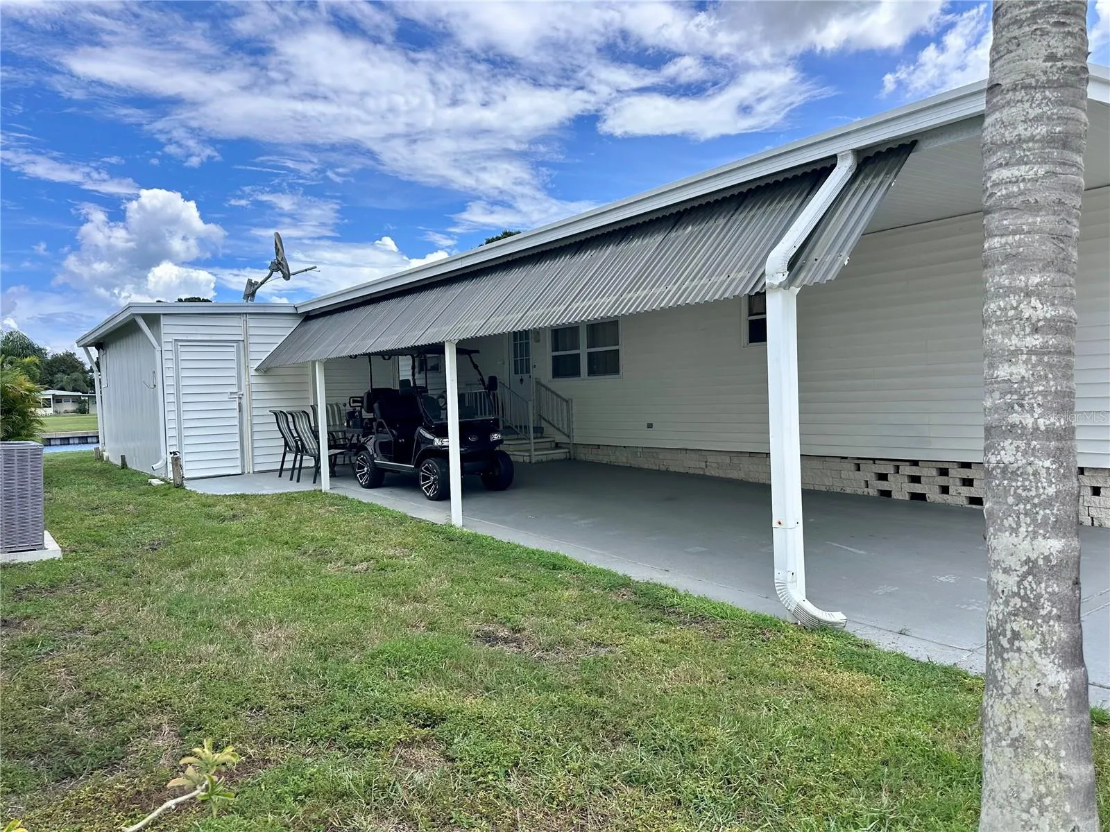 Side large shed with room for golf cart parking.
