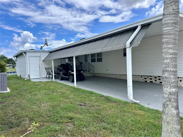 Side large shed with room for golf cart parking.