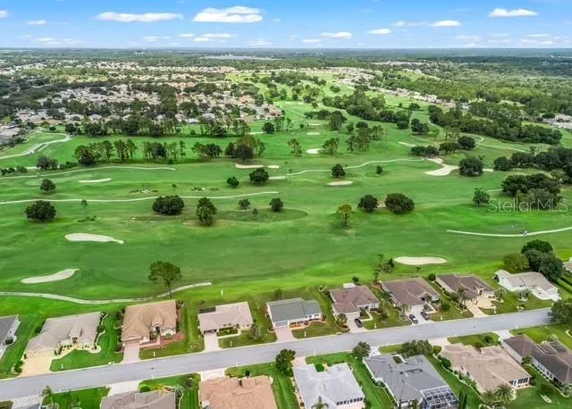 Aerial view showcases the beautiful golf course, highlighting the manicured fairways and picturesque surroundings that make this location so desirable.