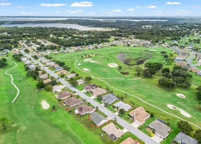 Aerial view showcases the surrounding neighborhood, highlighting the community layout, nearby homes, and the picturesque area surrounding the property.