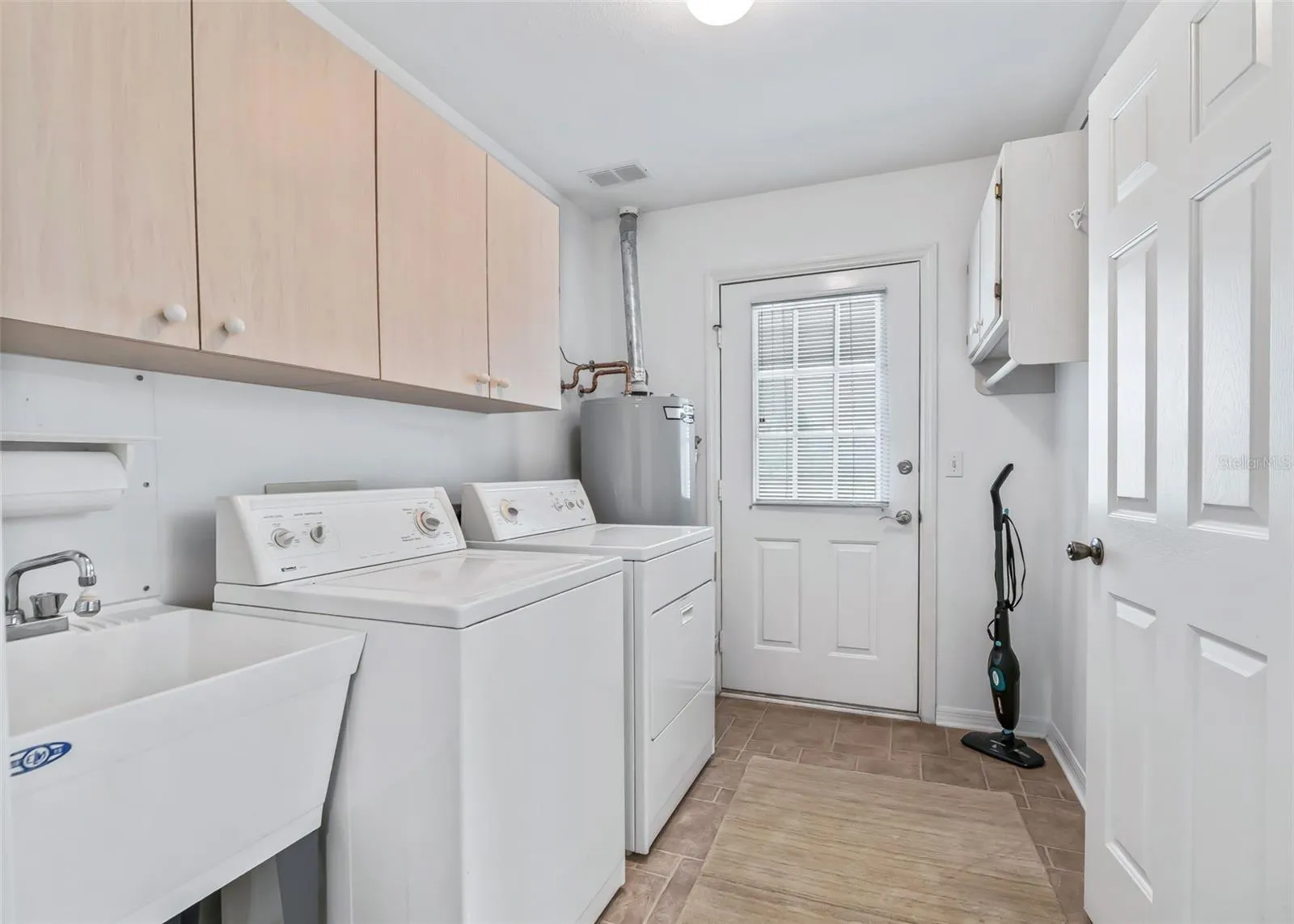 Convenient indoor laundry room includes a washer and dryer, with direct access to the back patio for added ease and functionality.