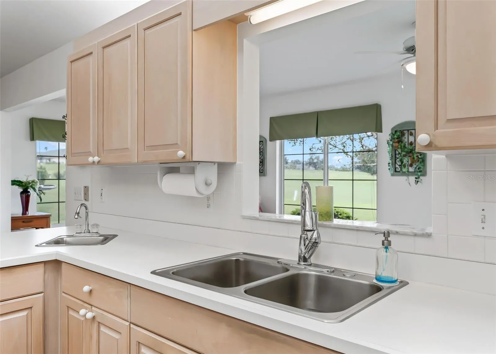 Functional kitchen featuring convenient pass-through window overlooking the bonus living space.