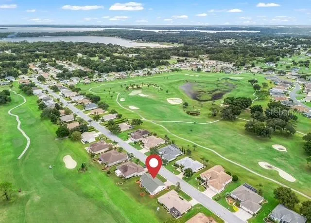 Aerial view showcases the surrounding neighborhood, highlighting the community layout, nearby homes, and the picturesque area surrounding the property.