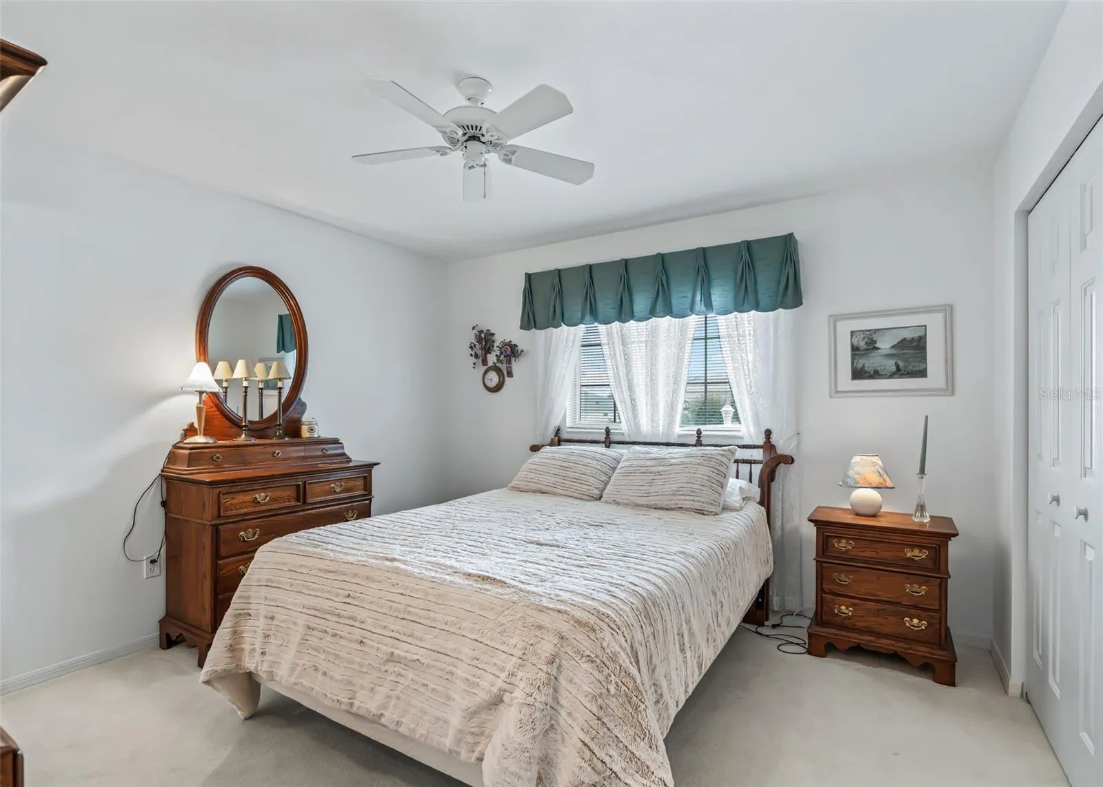 Comfortable guest bedroom features a ceiling fan and a bright, welcoming atmosphere, making it a cozy space for family or overnight guests.
