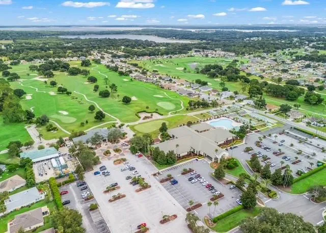 Aerial view showcases the properties convenient location within the community, highlighting the home’s proximity to the community center and neighborhood amenities.