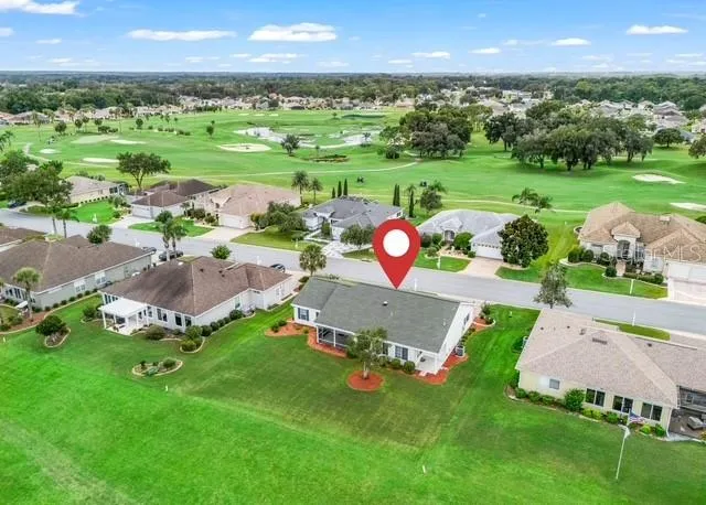Aerial view showcases the home’s beautiful location along the golf course, highlighting the property, surrounding neighborhood, and picturesque golf course setting.