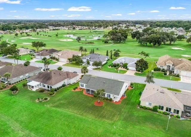 Aerial view showcases the home’s beautiful location along the golf course, highlighting the property, surrounding neighborhood, and picturesque golf course setting.