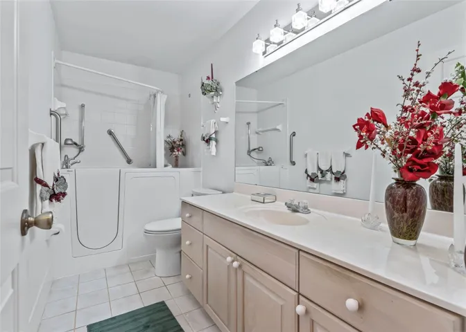 Bright and inviting guest bathroom features a convenient walk-in tub, offering both comfort and ease of use.