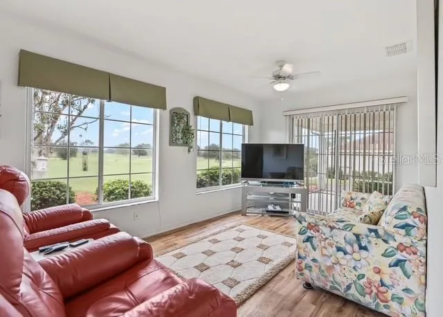 Additional living space off the kitchen offers a comfortable area for relaxing or entertaining and opens directly to the enclosed lanai, creating a seamless indoor-outdoor living experience.