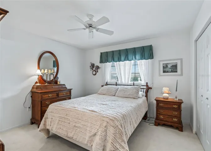 Comfortable guest bedroom features a ceiling fan and a bright, welcoming atmosphere, making it a cozy space for family or overnight guests.