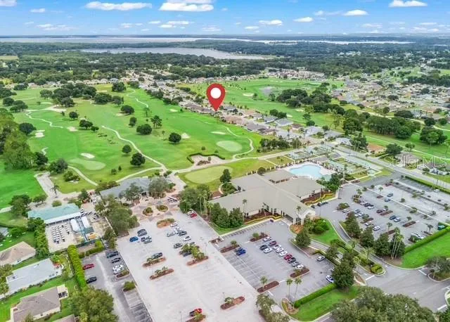 Aerial view showcases the properties convenient location within the community, highlighting the home’s proximity to the community center and neighborhood amenities.