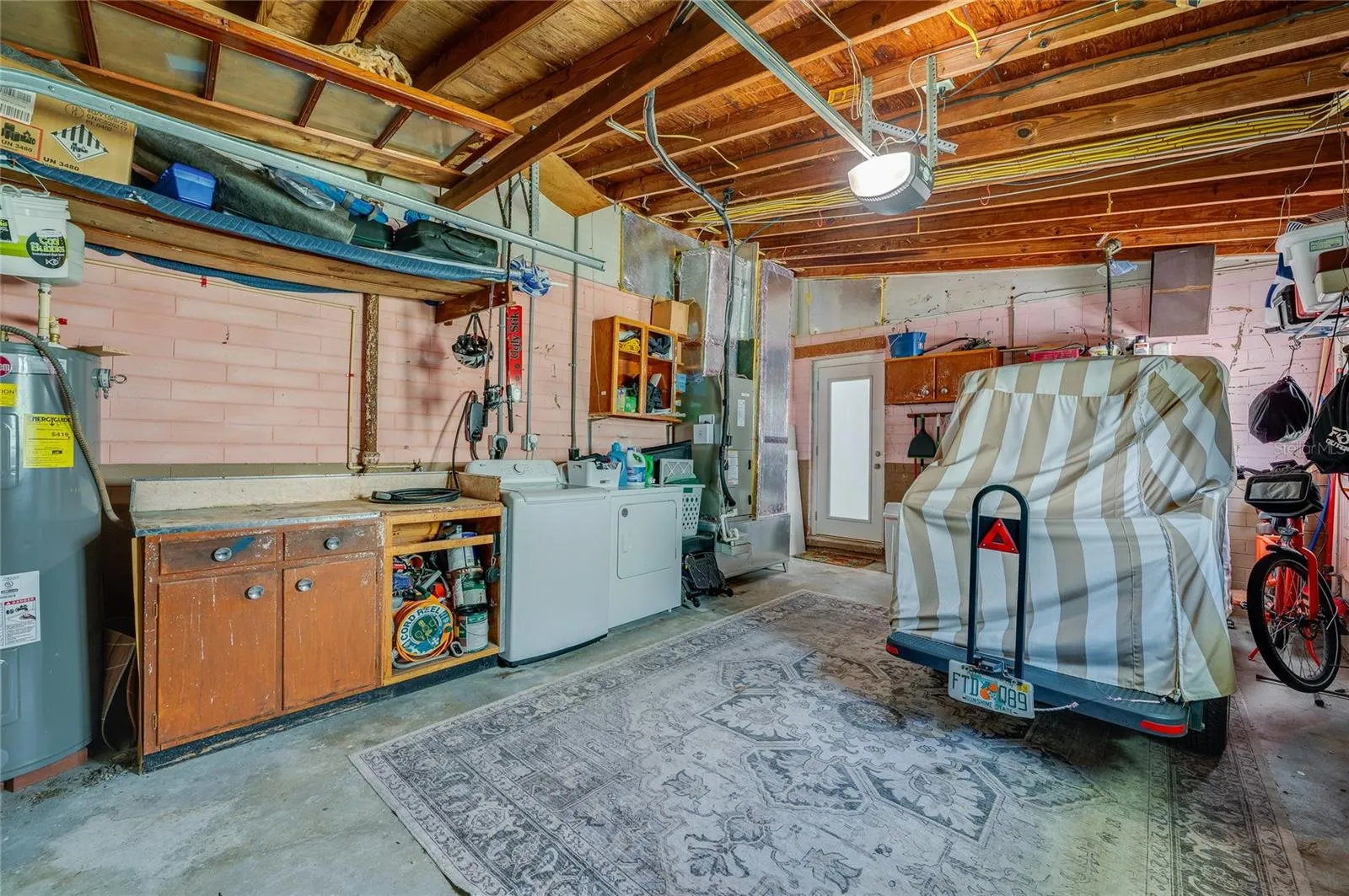 Functional garage setup complete with in-unit laundry appliances, an integrated workbench, and dedicated space for vehicle storage.