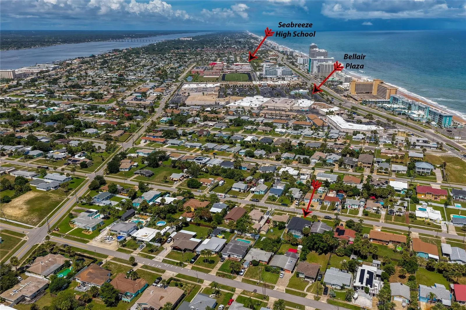 Wide aerial shot pointing out the residence's convenient proximity to local landmarks, including Bellair Plaza and Seabreeze High School.