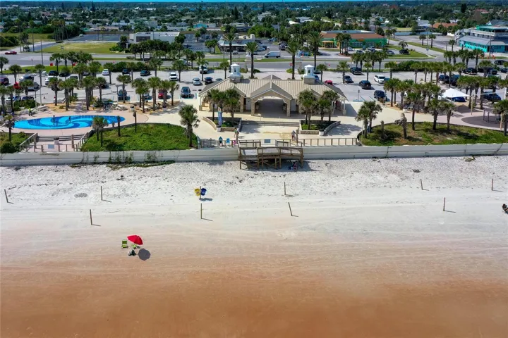 Aerial view showcases nearby Andy Romano Beachfront Park with direct Atlantic Ocean access, beachfront facilities, palm-lined grounds, and convenient parking.