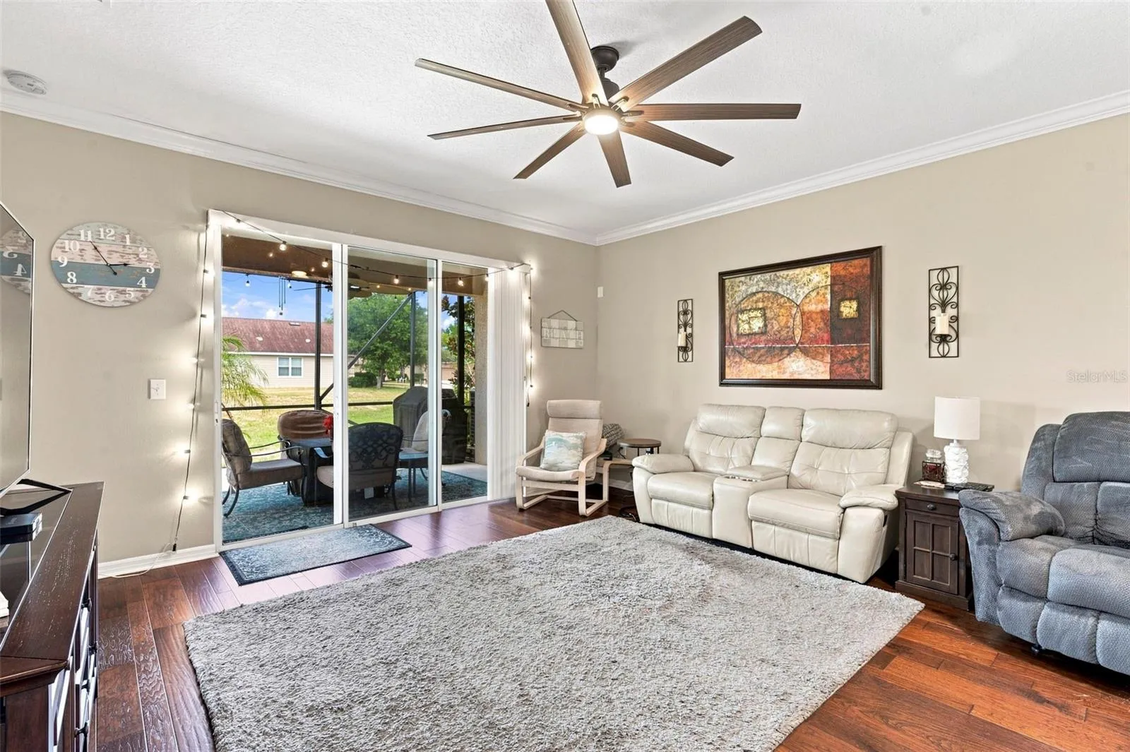 Living room with crown moldings and sliders to the lanai