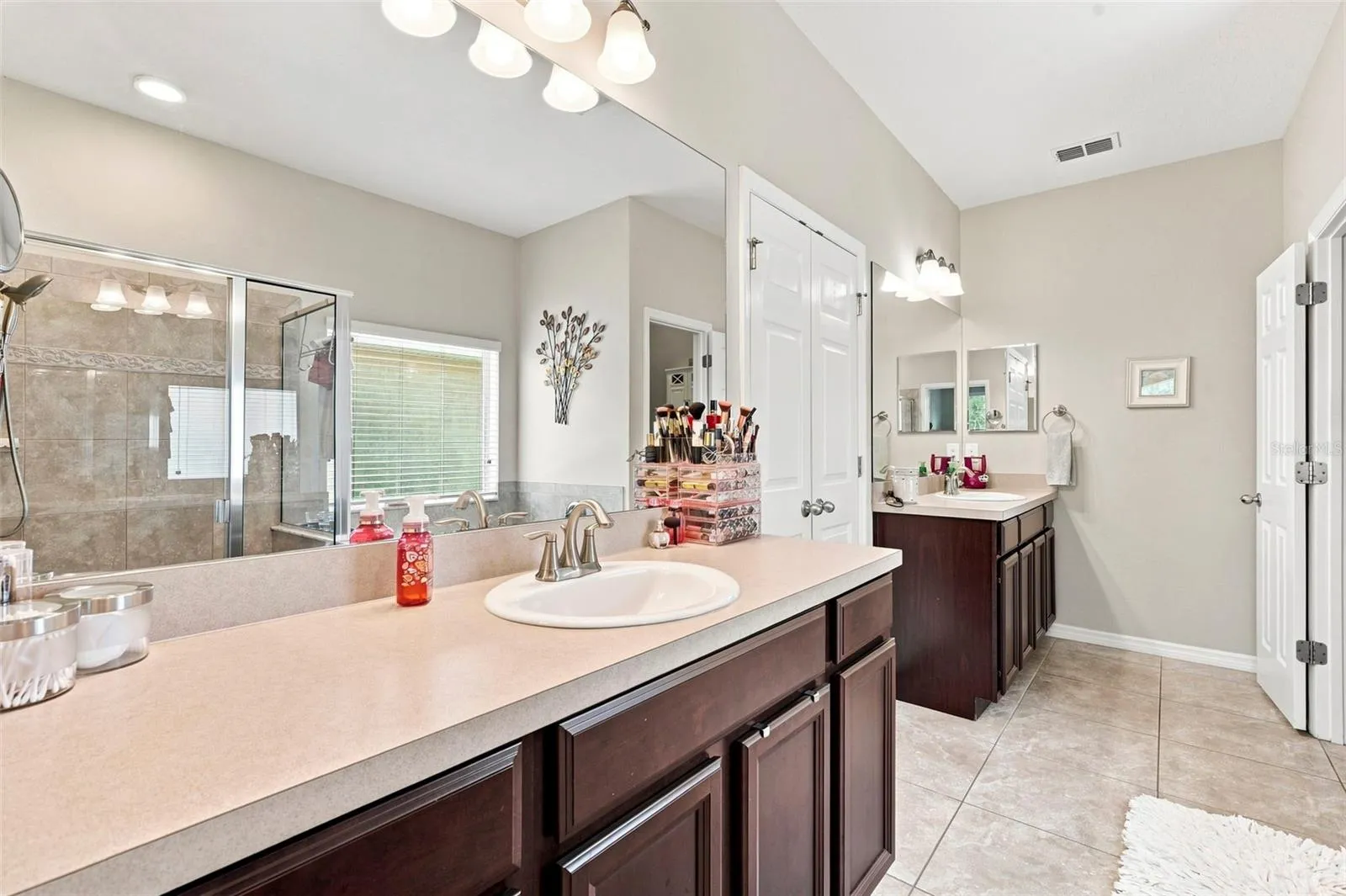 The spacious bathroom features dual vanities