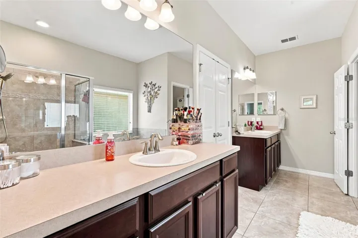 The spacious bathroom features dual vanities