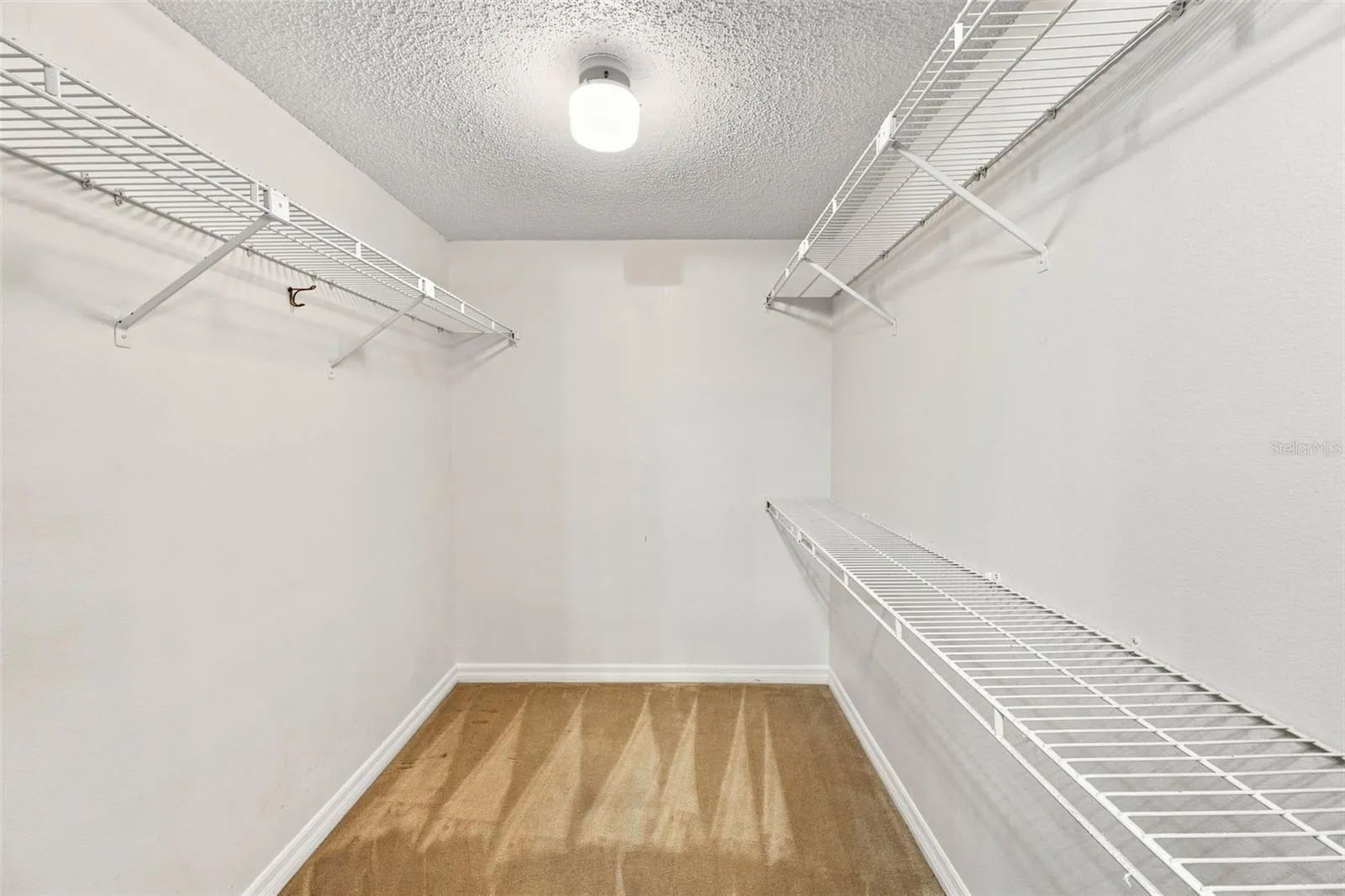 One of two walk-in closets in primary bedroom